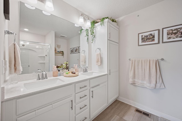 18874 72nd Pl N, Maple Grove, MN 55311 - full bathroom featuring a textured ceiling, double vanity, and a shower stall