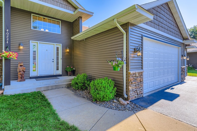 40224 Golden Way, North Branch, MN 55056 - doorway to property with an attached garage, driveway, and stone siding