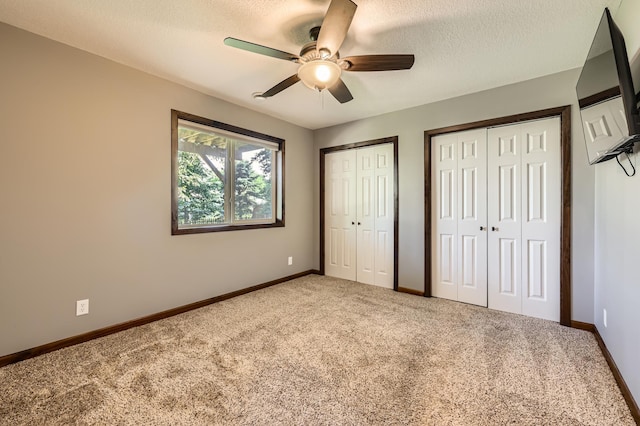 40224 Golden Way, North Branch, MN 55056 - unfurnished bedroom with carpet, two closets, a textured ceiling, and ceiling fan