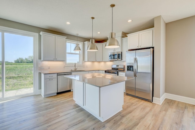 2885 Trinity Dr, Shakopee, MN 55379 - kitchen with stainless steel appliances, light wood-type flooring, decorative backsplash, a center island, and recessed lighting