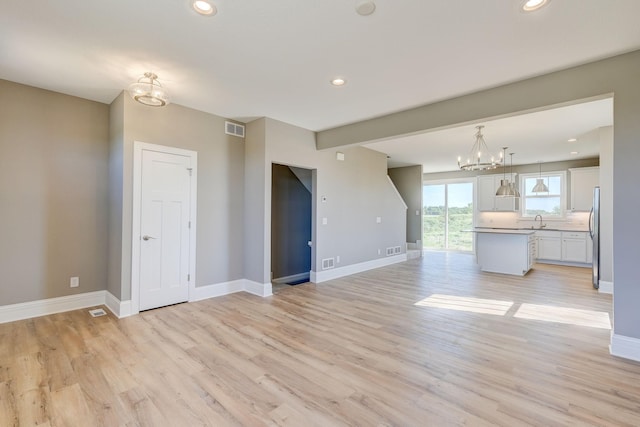 2885 Trinity Dr, Shakopee, MN 55379 - unfurnished living room featuring a chandelier, light wood-type flooring, and recessed lighting