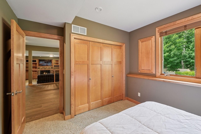 15208 Fairway Heights Rd NW, Prior Lake, MN 55372 - carpeted bedroom with a closet and a warm lit fireplace