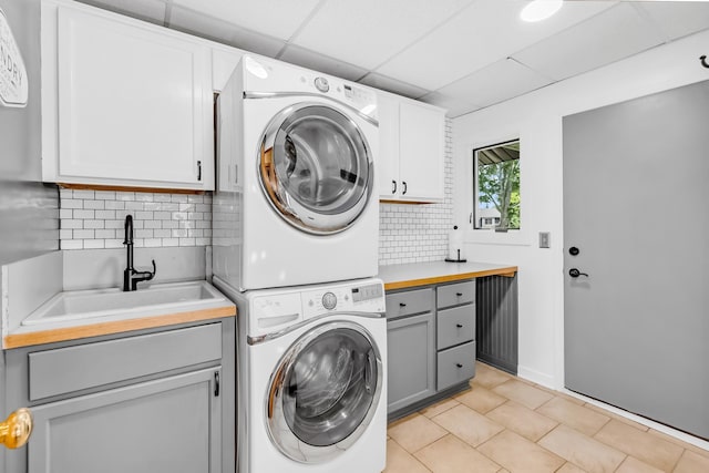 4619 Heather Way N, Oakdale, MN 55128 - laundry room featuring cabinet space, estacked washer and dryer, and light tile patterned floors