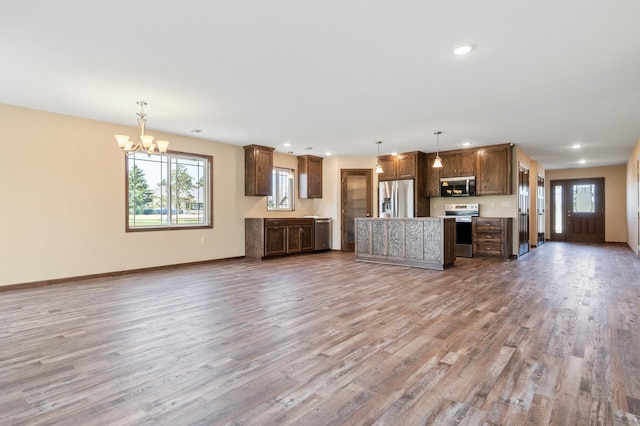 607 Colfax St, Parkers Prairie, MN 56361 - unfurnished living room featuring wood finished floors, a chandelier, and recessed lighting