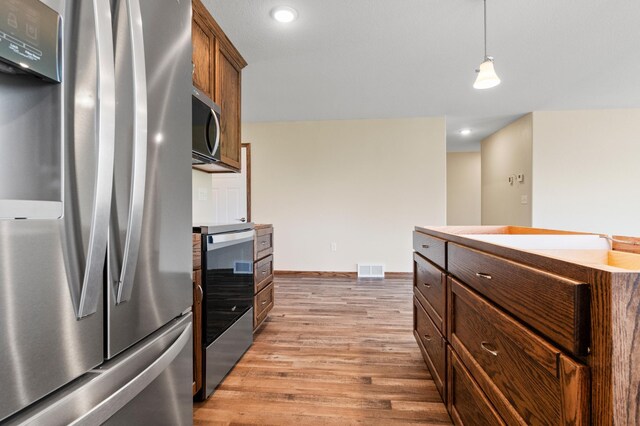 607 Colfax St, Parkers Prairie, MN 56361 - kitchen with appliances with stainless steel finishes, light wood finished floors, decorative light fixtures, recessed lighting, and light countertops