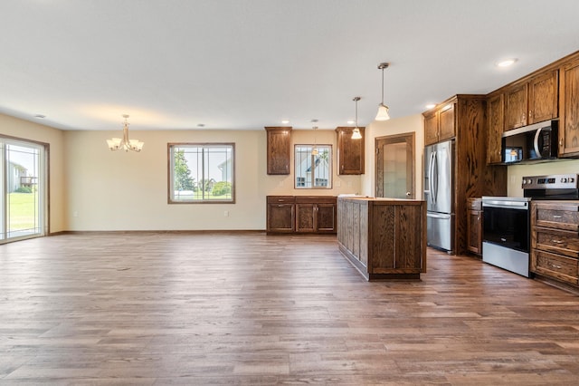 607 Colfax St, Parkers Prairie, MN 56361 - kitchen with stainless steel appliances, dark wood-style flooring, a chandelier, a kitchen island, and pendant lighting