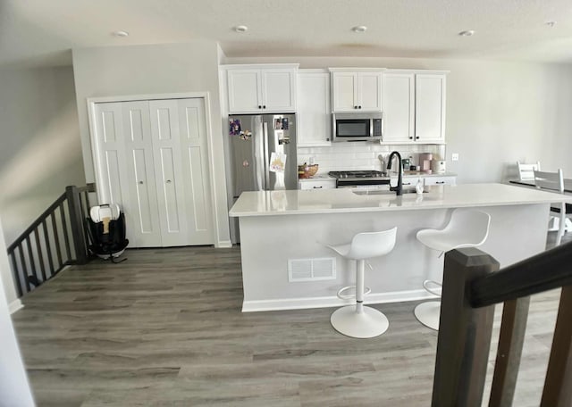 7628 Carla Path, Inver Grove Heights, MN 55076 - kitchen featuring stainless steel appliances, wood finished floors, decorative backsplash, light countertops, and recessed lighting