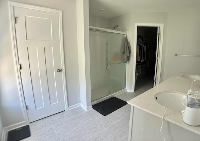 7628 Carla Path, Inver Grove Heights, MN 55076 - full bath featuring a stall shower, a spacious closet, double vanity, and tile patterned flooring