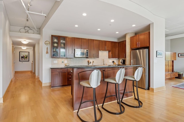 150 2nd St NE Unit B302, Minneapolis, MN 55413 - kitchen with appliances with stainless steel finishes, a breakfast bar, light wood-style floors, backsplash, and recessed lighting