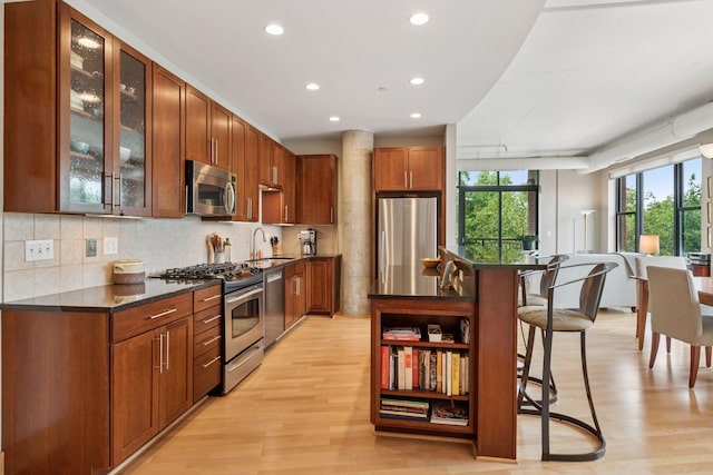 150 2nd St NE Unit B302, Minneapolis, MN 55413 - kitchen with appliances with stainless steel finishes, recessed lighting, light wood-style flooring, backsplash, and a kitchen breakfast bar