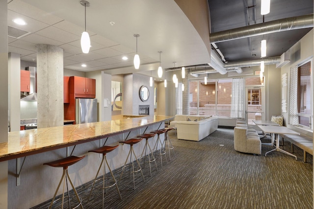 150 2nd St NE Unit B302, Minneapolis, MN 55413 - kitchen with freestanding refrigerator, dark carpet, a breakfast bar area, and pendant lighting