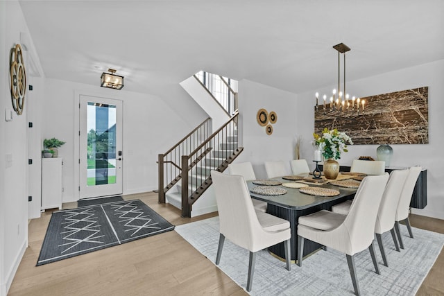 9612 Iron Horse Rd, Woodbury, MN 55129 - dining area featuring a chandelier, stairs, and wood finished floors