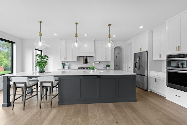 9612 Iron Horse Rd, Woodbury, MN 55129 - kitchen with stainless steel appliances, light countertops, white cabinetry, decorative backsplash, and recessed lighting