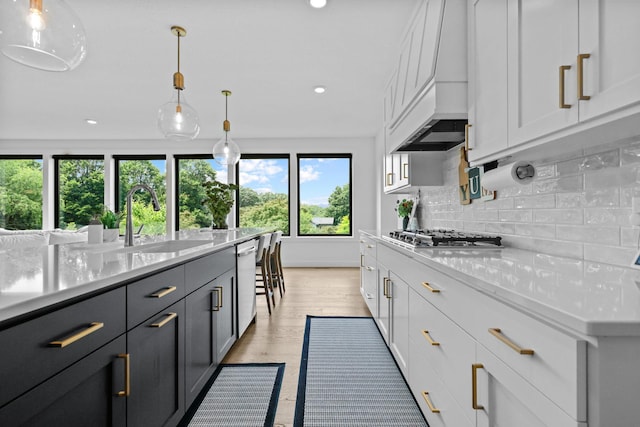 9612 Iron Horse Rd, Woodbury, MN 55129 - kitchen featuring appliances with stainless steel finishes, light countertops, backsplash, recessed lighting, and custom exhaust hood