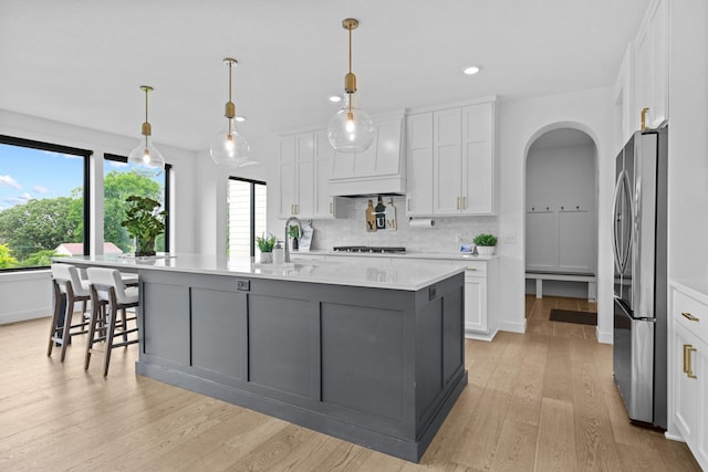 9612 Iron Horse Rd, Woodbury, MN 55129 - kitchen featuring freestanding refrigerator, white cabinets, light countertops, light wood finished floors, and recessed lighting