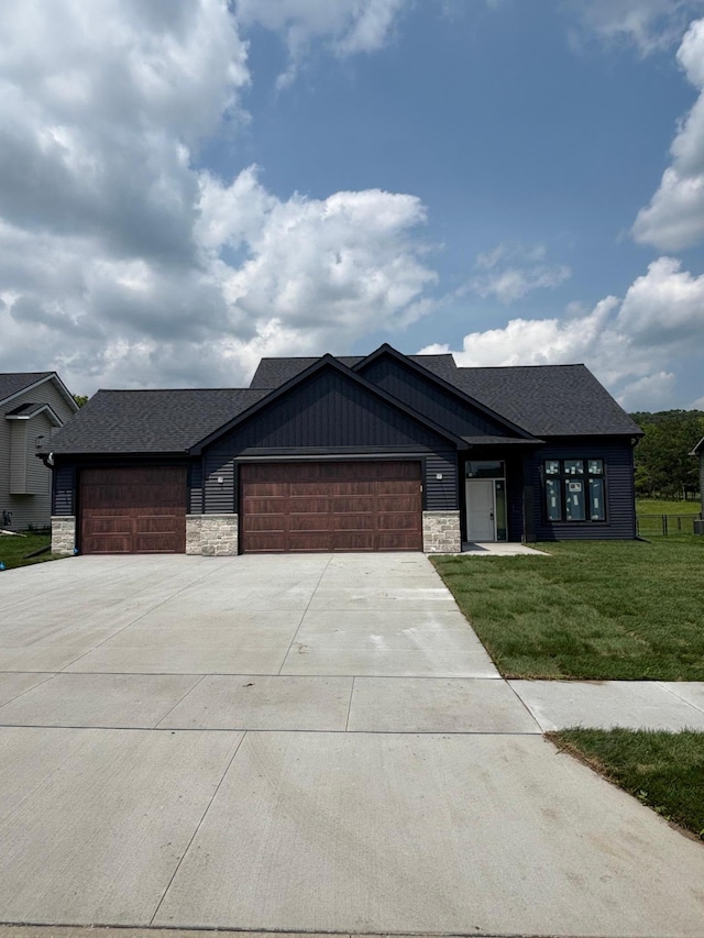 3641 18th St SE, Rochester, MN 55904 - view of front facade featuring a garage, concrete driveway, a front lawn, and stone siding