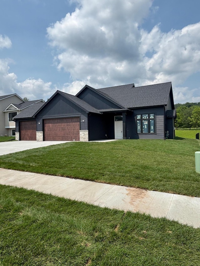 3641 18th St SE, Rochester, MN 55904 - view of front of property with a garage, a front lawn, stone siding, a shingled roof, and driveway