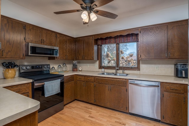 301 Nottingham Ct, North Mankato, MN 56003 - kitchen with appliances with stainless steel finishes, light wood finished floors, light countertops, and a ceiling fan