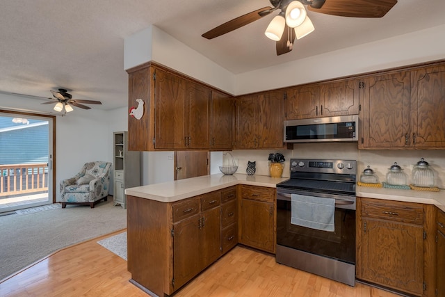 301 Nottingham Ct, North Mankato, MN 56003 - kitchen with appliances with stainless steel finishes, a ceiling fan, light countertops, a peninsula, and light wood-style floors