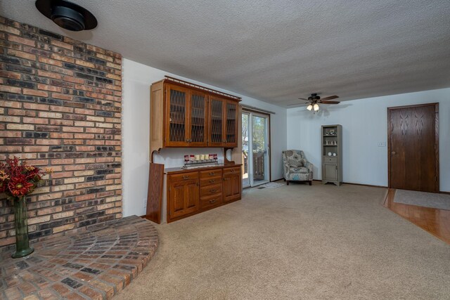 301 Nottingham Ct, North Mankato, MN 56003 - kitchen with a textured ceiling, brown cabinetry, light colored carpet, a ceiling fan, and glass insert cabinets