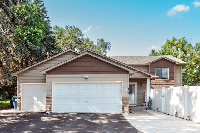 307 Hayden Lake Rd W, Champlin, MN 55316 - view of front of property featuring asphalt driveway, an attached garage, and stone siding