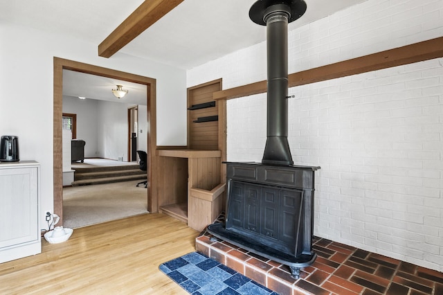 11542 Xavis St NW, Coon Rapids, MN 55433 - detailed view of a wood stove, beamed ceiling, and wood finished floors