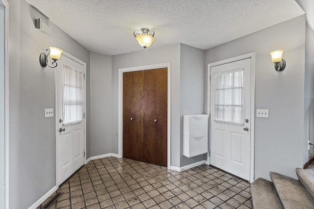 11542 Xavis St NW, Coon Rapids, MN 55433 - entrance foyer featuring a textured ceiling and stairs