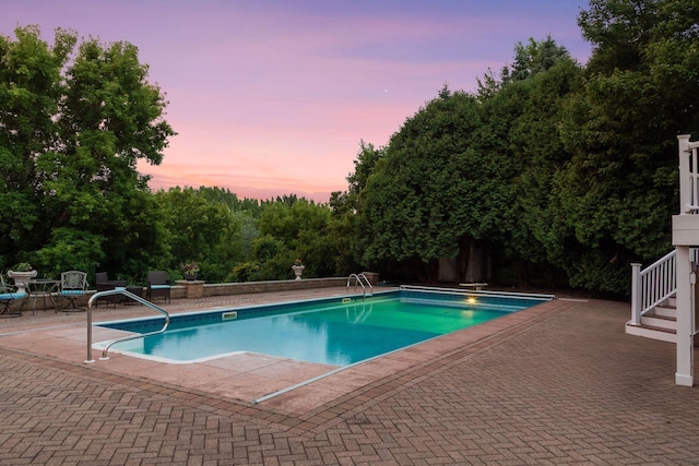 10 Apple Orchard Ct, Dellwood, MN 55110 - pool at dusk featuring a patio, an outdoor pool, and a diving board