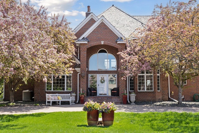 10 Apple Orchard Ct, Dellwood, MN 55110 - property entrance with a chimney, a yard, and brick siding