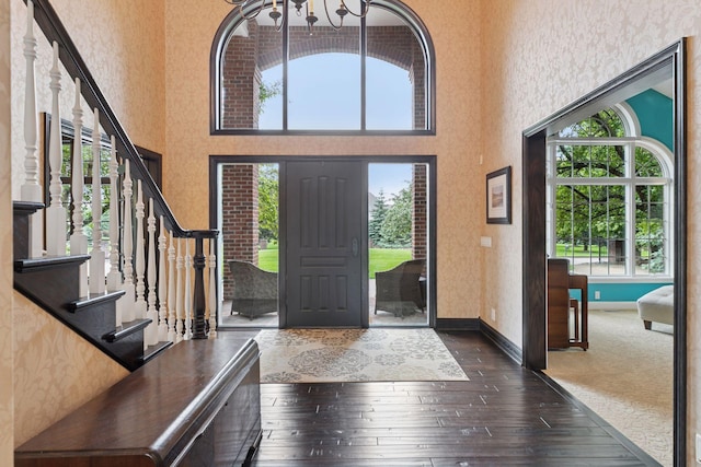 10 Apple Orchard Ct, Dellwood, MN 55110 - foyer entrance with a chandelier, dark wood-style flooring, stairs, a high ceiling, and wallpapered walls