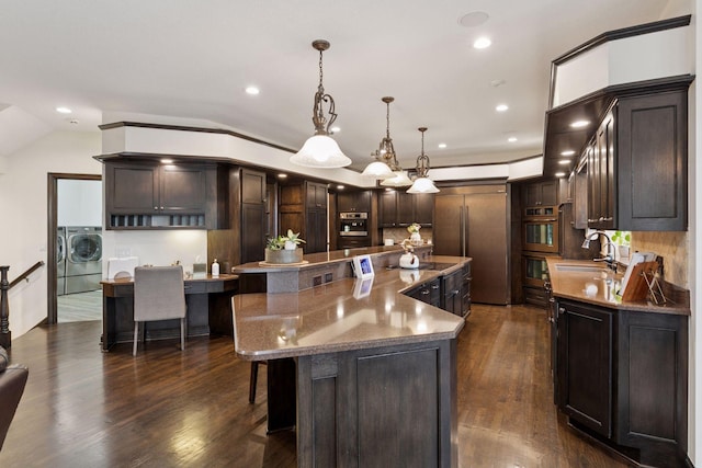 10 Apple Orchard Ct, Dellwood, MN 55110 - kitchen featuring washing machine and dryer, paneled fridge, a large island, dark wood-style flooring, and dark brown cabinets