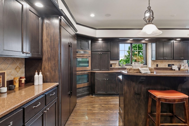 10 Apple Orchard Ct, Dellwood, MN 55110 - kitchen with double oven, a kitchen breakfast bar, dark wood-style floors, tasteful backsplash, and stone countertops