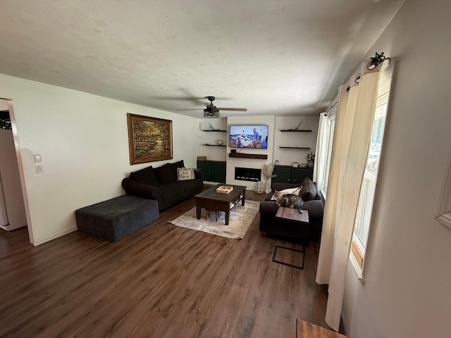 122 3rd St E, Morgan, MN 56266 - living area with wood finished floors, a ceiling fan, and a fireplace