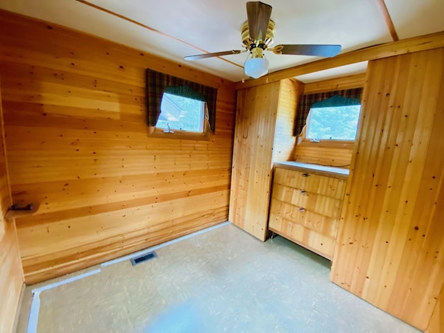W7486 Burval Dr, Minong, WI 54859 - empty room featuring wooden walls, plenty of natural light, and ceiling fan