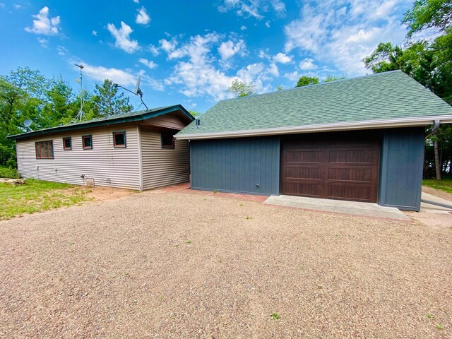 W7486 Burval Dr, Minong, WI 54859 - single story home with a garage, an outbuilding, and roof with shingles