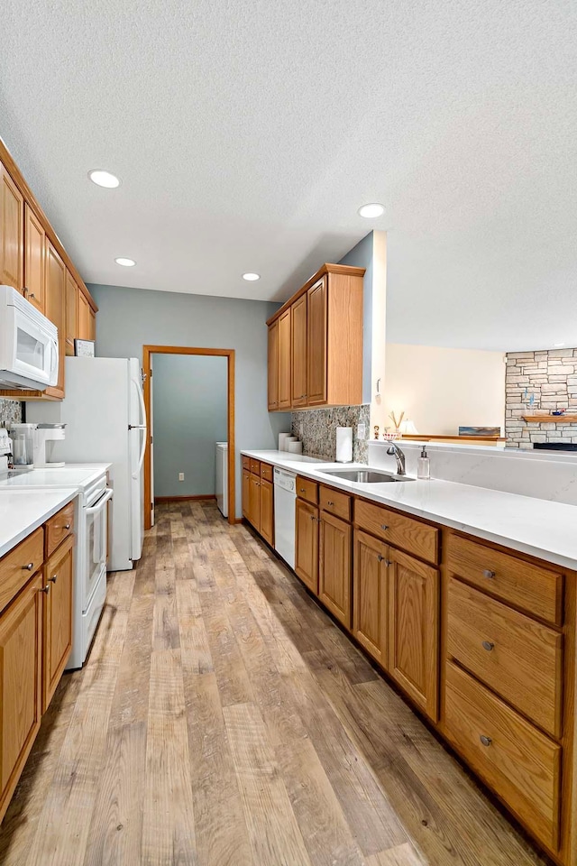 1112 Iris Dr, White Bear Twp, MN 55127 - kitchen featuring white appliances, backsplash, light wood-style floors, a textured ceiling, and light countertops