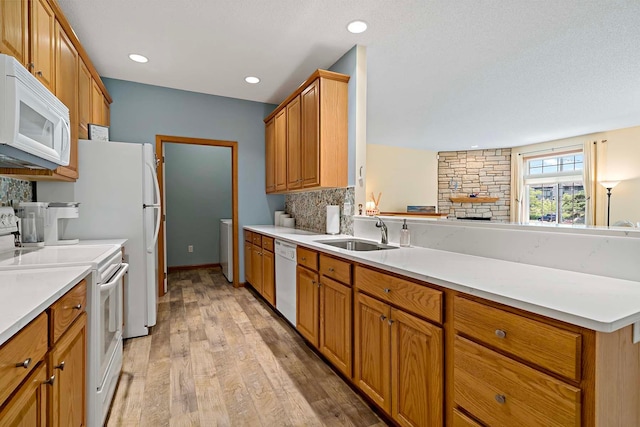 1112 Iris Dr, White Bear Twp, MN 55127 - kitchen featuring white appliances, tasteful backsplash, light wood-style floors, light countertops, and brown cabinetry