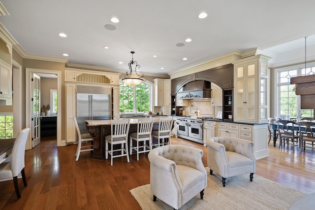 18901 Brookwood Rd, Prior Lake, MN 55372 - kitchen featuring premium appliances, cream cabinetry, crown molding, a center island, and a kitchen breakfast bar
