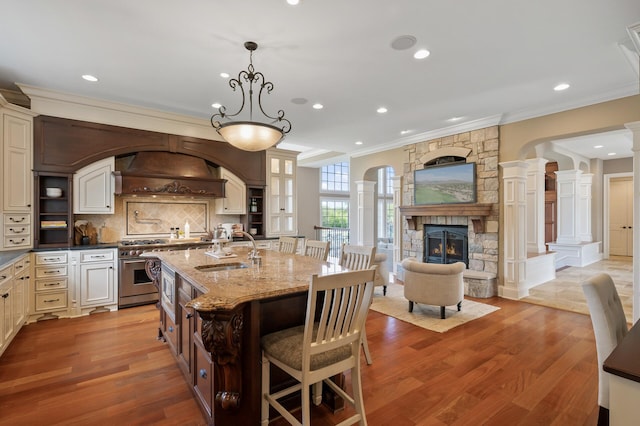 18901 Brookwood Rd, Prior Lake, MN 55372 - kitchen with crown molding, custom exhaust hood, tasteful backsplash, open floor plan, and ornate columns