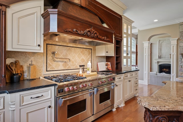18901 Brookwood Rd, Prior Lake, MN 55372 - kitchen featuring double oven range, custom range hood, light wood-style floors, a fireplace, and crown molding