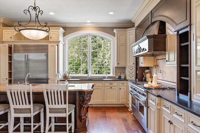 18901 Brookwood Rd, Prior Lake, MN 55372 - kitchen with cream cabinetry, high end appliances, premium range hood, wood-type flooring, and crown molding