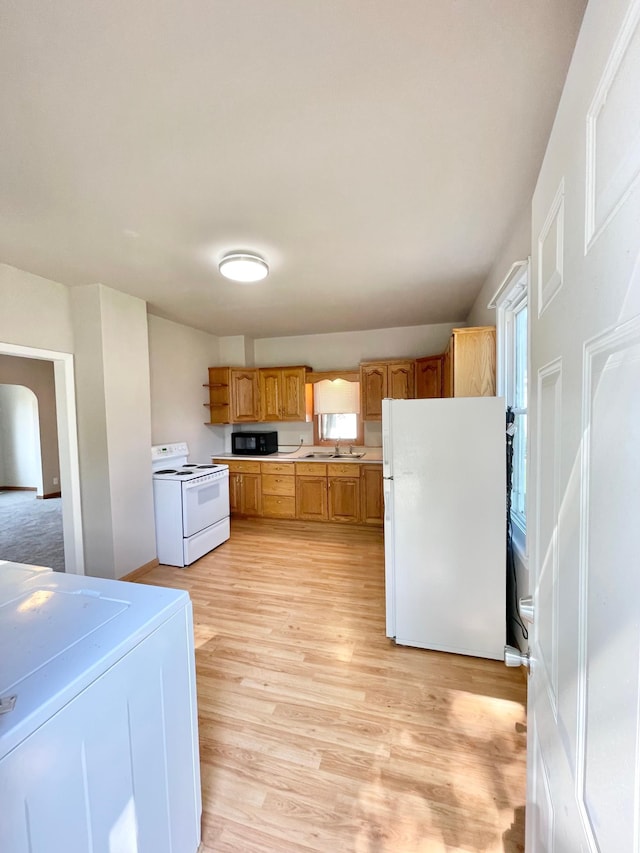 422 Sanborn St, Springfield, MN 56087 - kitchen with white appliances, washer / clothes dryer, light countertops, light wood-style flooring, and brown cabinetry