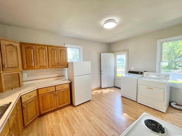422 Sanborn St, Springfield, MN 56087 - kitchen with freestanding refrigerator, light wood-style flooring, brown cabinets, separate washer and dryer, and light countertops