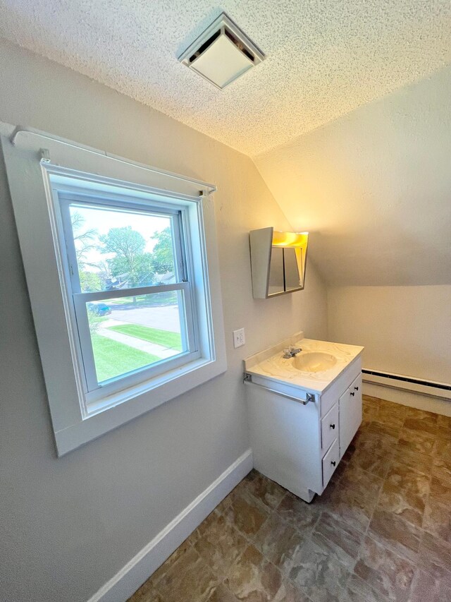 422 Sanborn St, Springfield, MN 56087 - bathroom featuring a baseboard heating unit, vanity, lofted ceiling, and a textured ceiling