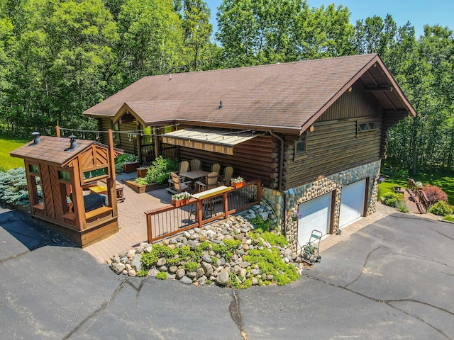 28395 Far N Dr, Nevis, MN 56467 - log-style house with log exterior, a deck, asphalt driveway, stone siding, and a shingled roof
