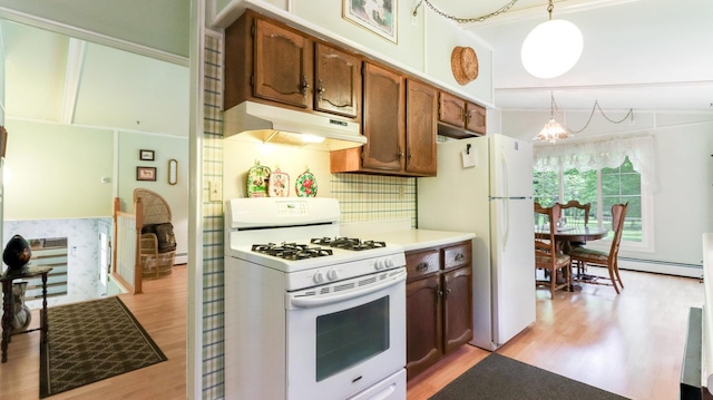 2104 US Highway 8, Stanley Twp, WI 54822 - kitchen with white appliances, under cabinet range hood, light wood finished floors, a chandelier, and decorative light fixtures