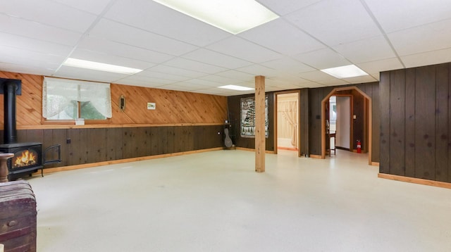 2104 US Highway 8, Stanley Twp, WI 54822 - below grade area with wood walls, a wood stove, and a drop ceiling