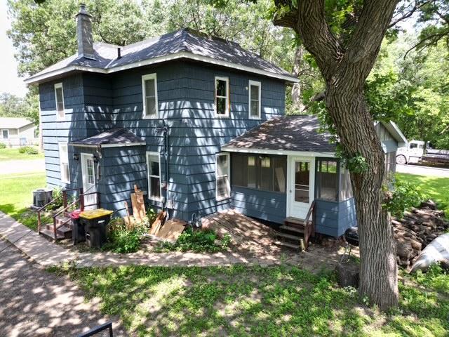 311 Grove St, Redwood Falls, MN 56283 - view of front of home with entry steps, a chimney, roof with shingles, and a sunroom