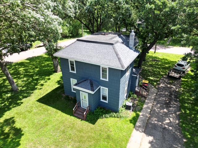 311 Grove St, Redwood Falls, MN 56283 - view of front facade featuring a chimney, a front lawn, and roof with shingles