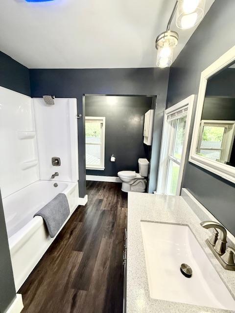 311 Grove St, Redwood Falls, MN 56283 - full bath featuring vanity, wood finished floors, and shower / bathtub combination